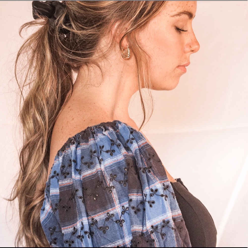 a puff sleeve blue and black crop top with snaps down the front